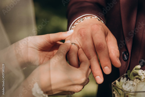 The bride wears a wedding ring to the groom at the wedding ceremony. Hand in hand. Wedding, holiday, engagement.