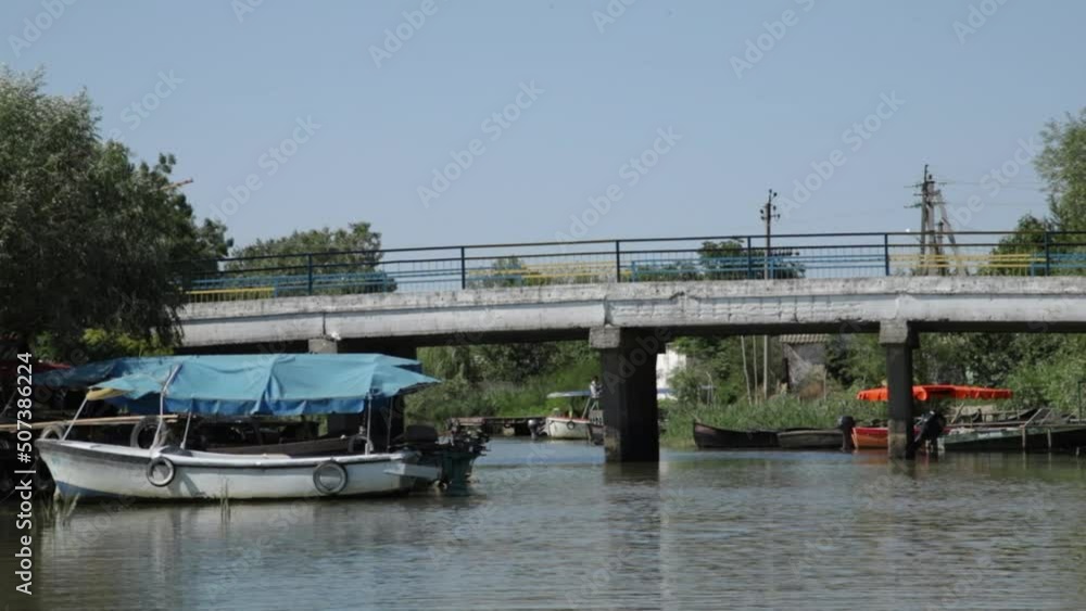 Vilkovo, Ukraine. May 2022. Beautiful view on river, boats and bridge with blue sky from the motor boat seat. Speedboat floating on water, tourism Vilkovo, Ukraine. May 2022. Beautiful view on river, boats and bridge with blue sky from the motor boat seat. Speedboat floating on water, tourism