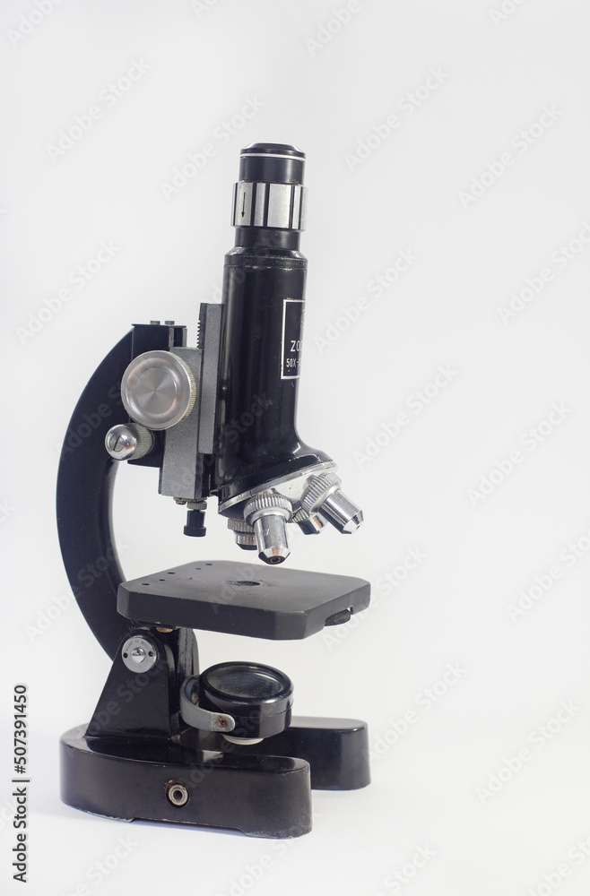 old analog microscope, mirror on white background with copy space old analog microscope, mirror on white background with copy space