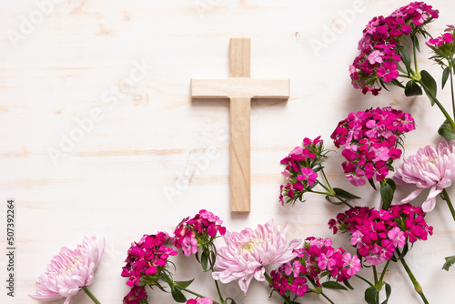 Fotografiet Wood Christian cross with border of pink flwoers on a white wood background with