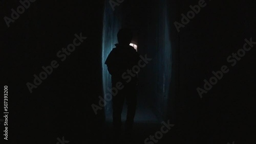 Kid with flashlights walking through dark tunnels