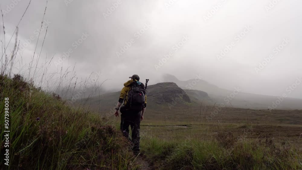 Walking Along a Hiking Trail in the Scottish Mountains and exiting frame around a corner Walking Along a Hiking Trail in the Scottish Mountains and exiting frame around a corner
