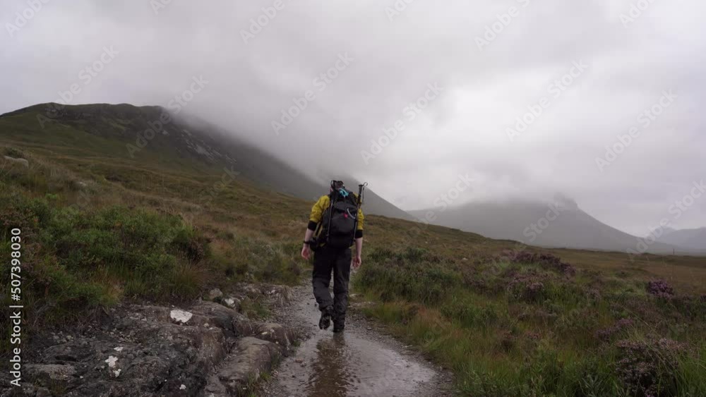 Man With Yellow Jacket Hiking through a misty Isle of Skye Trail Man With Yellow Jacket Hiking through a misty Isle of Skye Trail