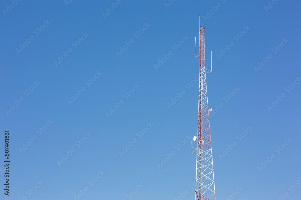 Telecommunication radio wave signal tower red white blue sky background Telecommunication radio wave signal tower red white blue sky background