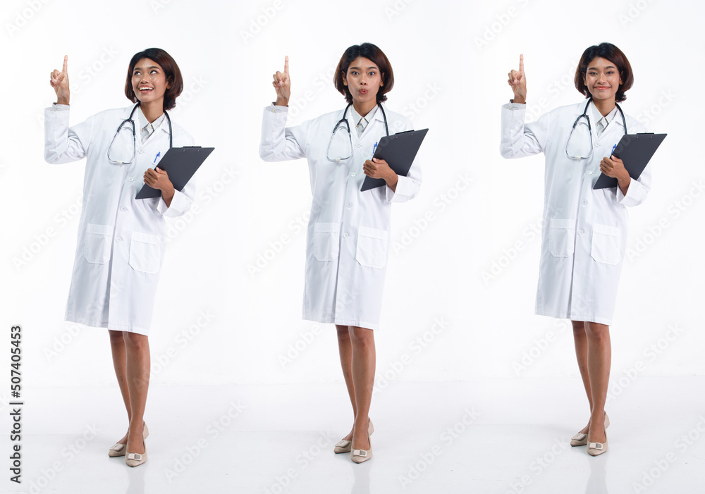 Full length 20s young Asian Doctor Woman wear stethoscope; uniform coat, pointing finger hand in air Full length 20s young Asian Doctor Woman wear stethoscope; uniform coat, pointing finger hand in air