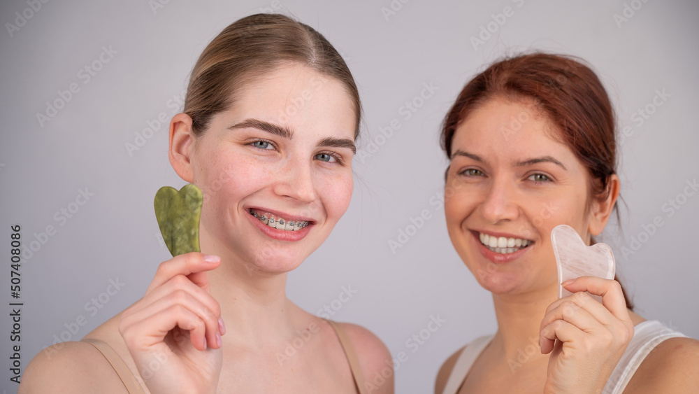 Portrait of two caucasian women with gouache scrapers on a white background. Portrait of two caucasian women with gouache scrapers on a white background.