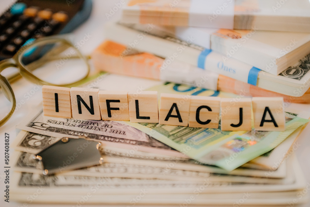 Fototapeta premium Napis inflacja na tle stosu banknotów