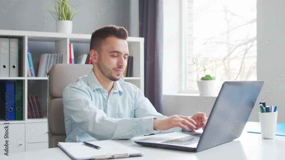 Young Man Works while Sitting in front of a Computer at Home. The Workplace of a Professional Worker, Freelancer or Student. Distance Work and Education Concept. Young Man Works while Sitting in front of a Computer at Home. The Workplace of a Professional Worker, Freelancer or Student. Distance Work and Education Concept.