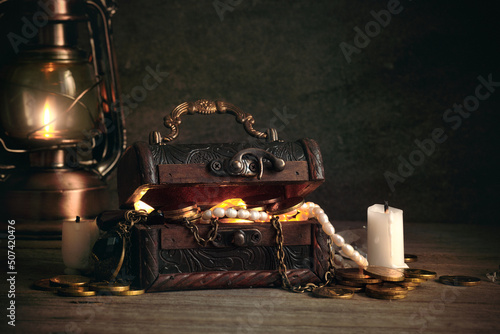 Photos a chest with pirate treasures and jewels on a wooden table in the captain's cabi