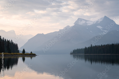 Colorful sunrise on the bank of still alpine lake with prominent mountain , Jasper NP, Canada