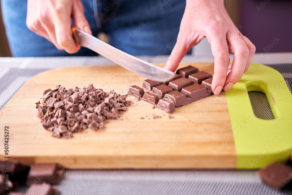 Chopping a Chocolate Bar while Making Chocolate Pudding or Baking