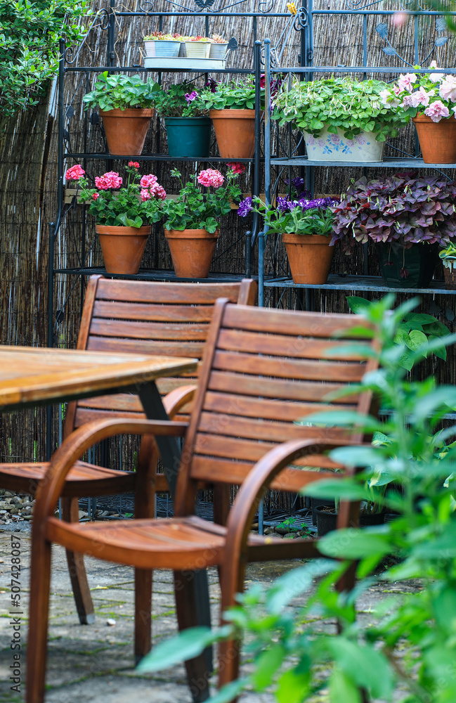 Secluded and Cosy Little Patio area in the urban citygarden with a wooden seating area and lots of green plants in planters