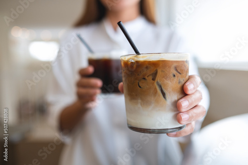 Closeup of a woman holding and serving two glasses of iced coffee photo