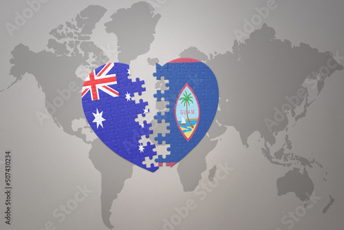 puzzle heart with the national flag of guam and australia on a world map background. Concept.