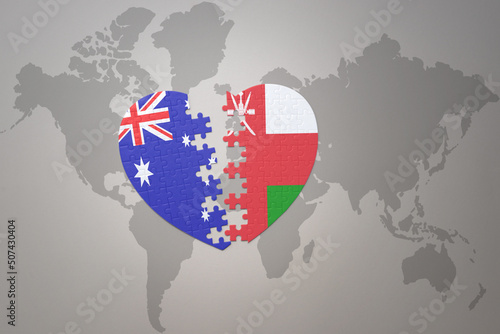 puzzle heart with the national flag of oman and australia on a world map background. Concept.