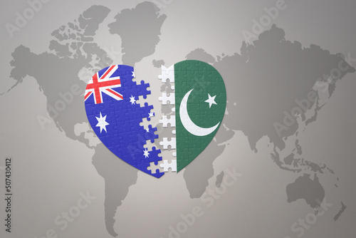 puzzle heart with the national flag of pakistan and australia on a world map background. Concept.