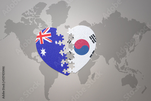 puzzle heart with the national flag of south korea and australia on a world map background. Concept.