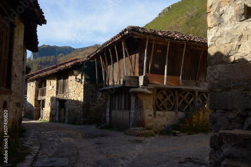Old asturian houses between mountains with blue sky