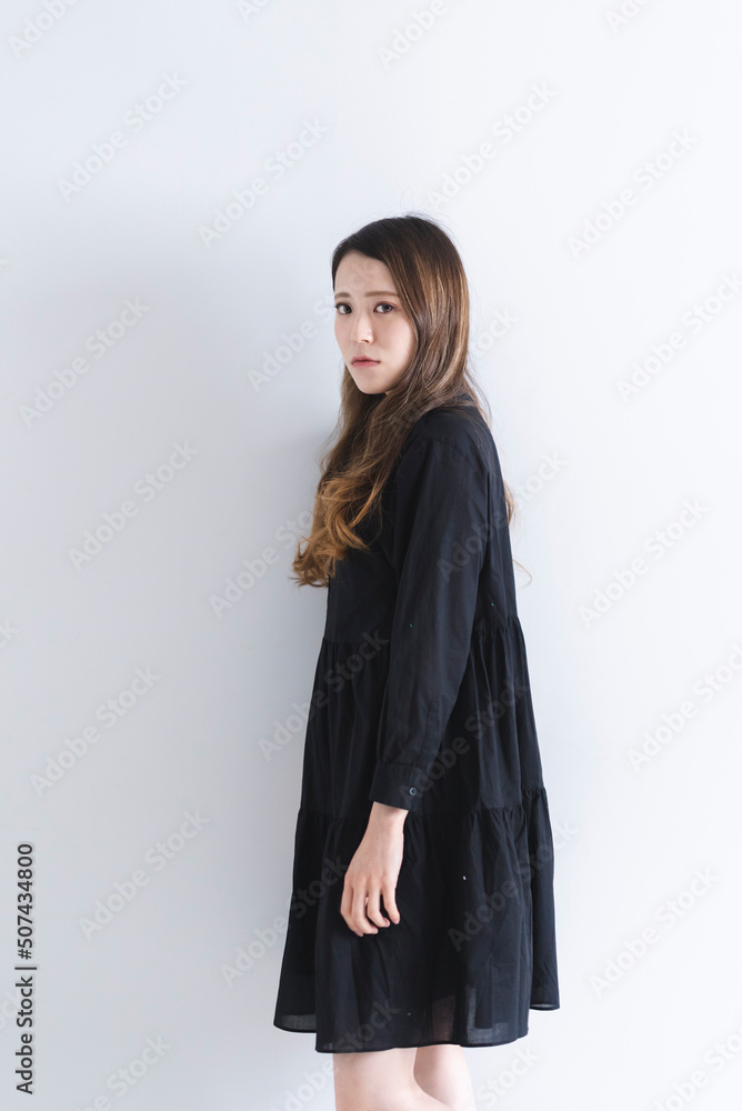 Fototapeta premium 黒いワンピースを着たロングヘアの女性