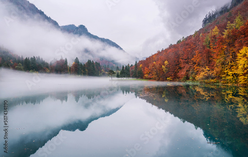 Autumn reflections at the emerald lake. Location is Zavrsnica valley in Slovenia.