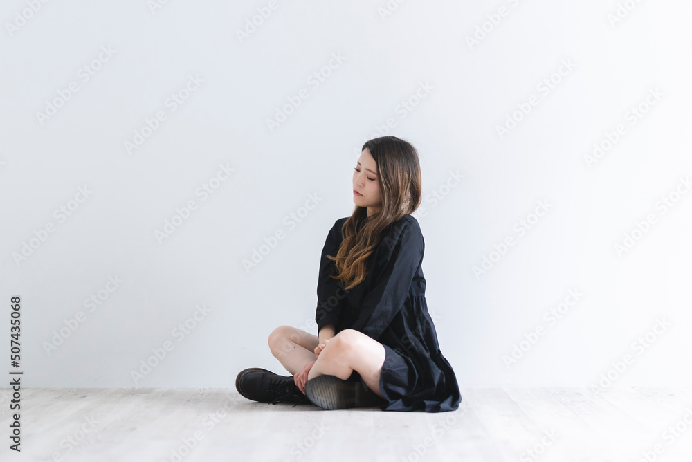 黒いワンピースを着たロングヘアのクールな女性