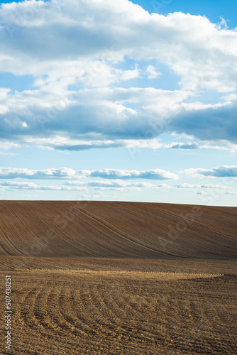 freshly plowed field during sunset evening cloudy blue sky