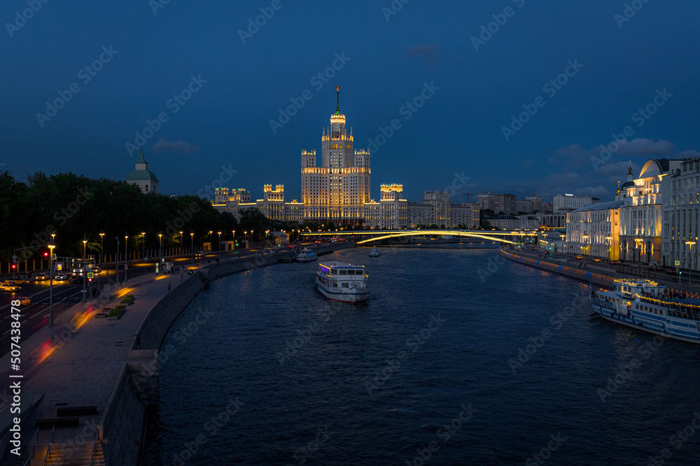 Fototapeta premium high-rise building on Kotelnicheskaya embankment on Moscow river. Evening cityscape of Moscow. Architecture and landmark of capital of Russia