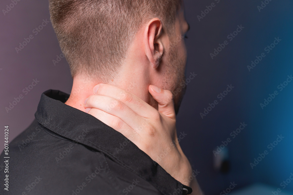 Close-up of a man independently kneading his neck and neck muscles long extensors of the neck. Neck pain Close-up of a man independently kneading his neck and neck muscles long extensors of the neck. Neck pain
