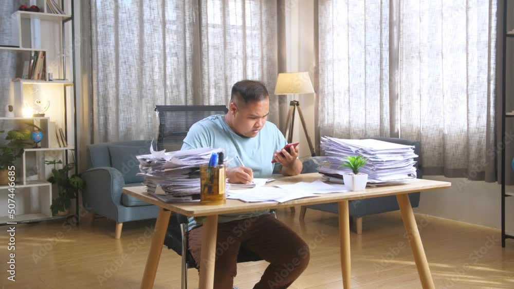 Fat Asian Man Talking On Phone And Taking Note While Working Hard With Documents At Office
Fat Asian Man Talking On Phone And Taking Note While Working Hard With Documents At Office