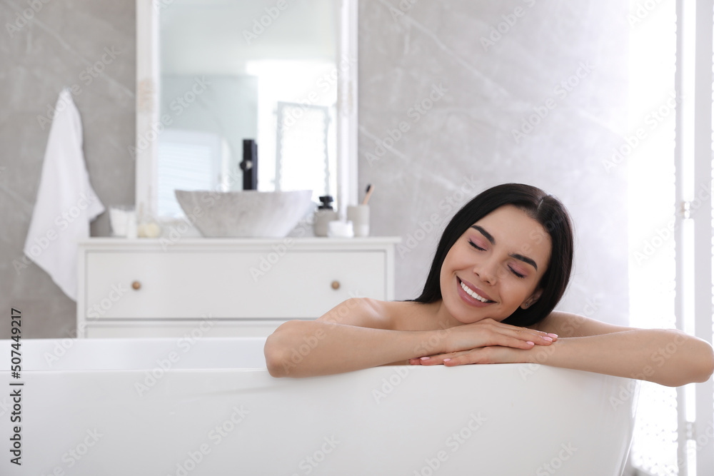 Beautiful young woman relaxing in bathtub at home Beautiful young woman relaxing in bathtub at home
