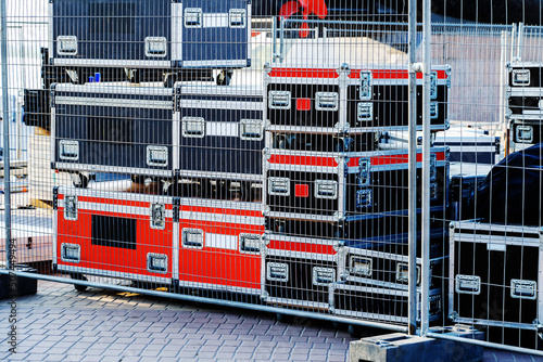 Concert equipment in metal boxes is located behind a metal fence. Preparation for mass events on the city street. selective focus