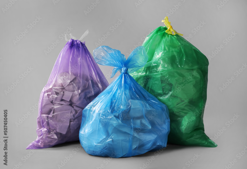 Trash bags full of garbage on grey background Trash bags full of garbage on grey background