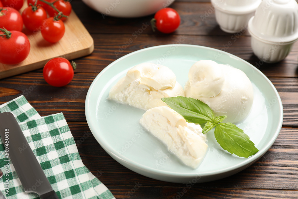 Delicious burrata cheese with basil served on wooden table