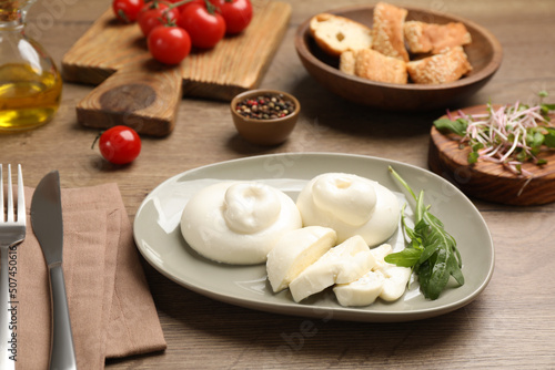 Delicious burrata cheese with arugula served on wooden table