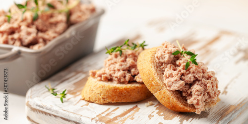 Fresh homemade goose liver pate on toasted bread with greens and capers.