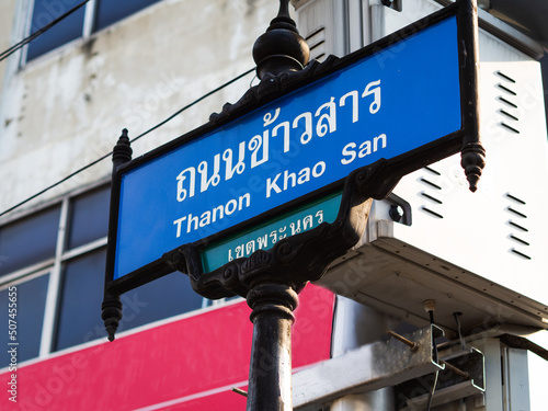 A blue and white street sign at famous Thanon Khao San Road in both Thai and English in Bangkok, Thailand.