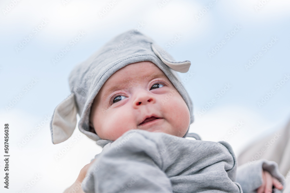 Professional baby photography outdoors. Baby child portrait towards blue sky. Joyful and happiness concept. Professional baby photography outdoors. Baby child portrait towards blue sky. Joyful and happiness concept.
