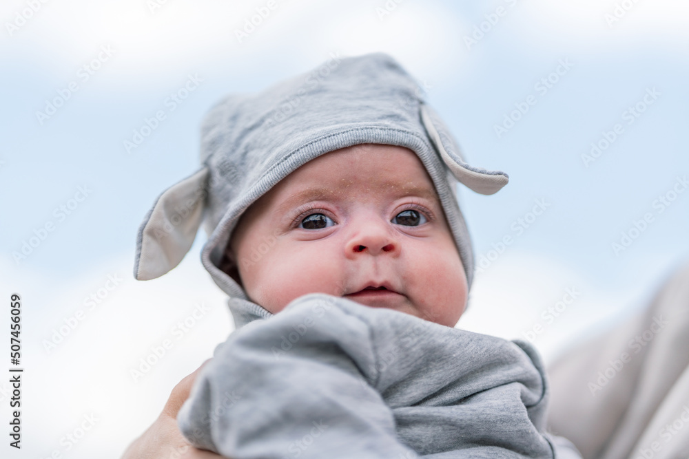 Professional baby photography outdoors. Baby child portrait towards blue sky. Joyful and happiness concept. Professional baby photography outdoors. Baby child portrait towards blue sky. Joyful and happiness concept.