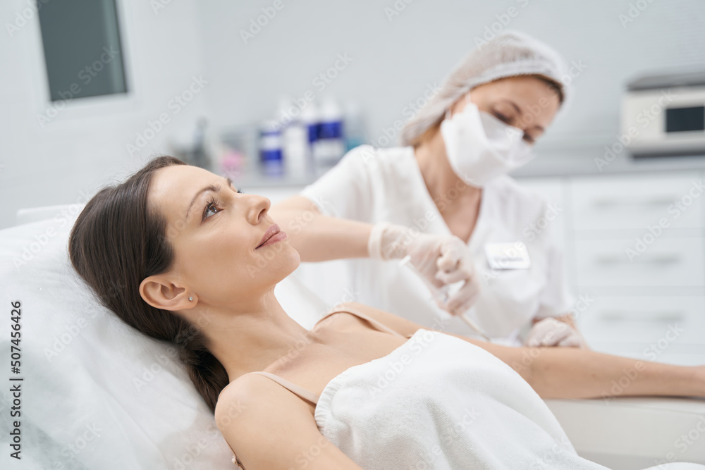 Obraz premium Woman receiving rejuvenating injection in cosmetology clinic
