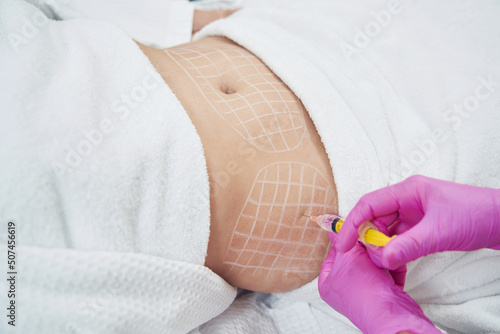 Dermatologist is doing injection into the subcutaneous fat in aesthetic clinic photo