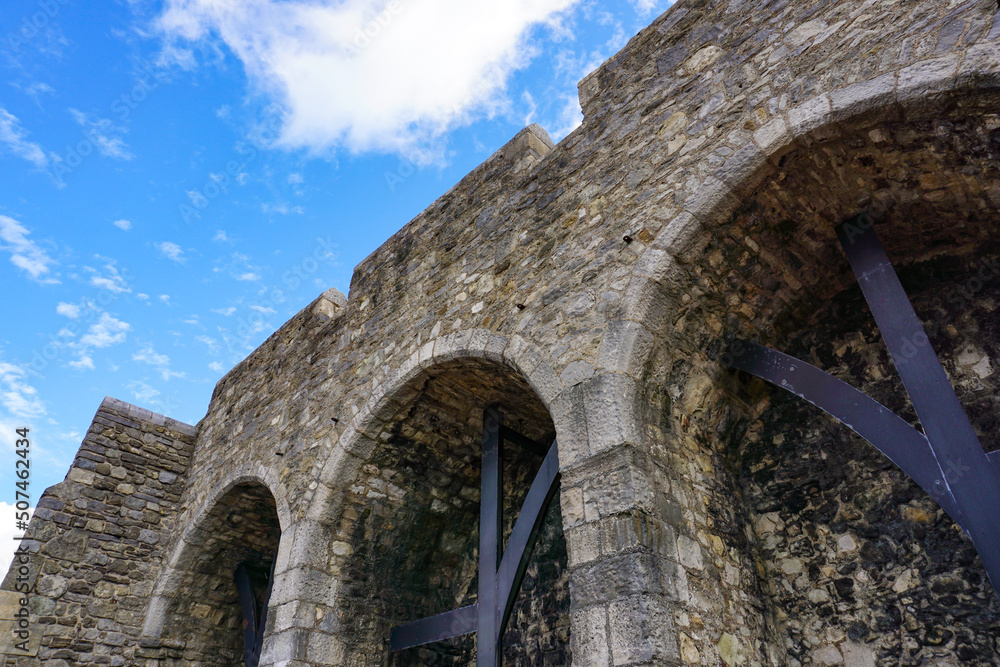 old historic stone walls in city. high medieval fortification walls with arches. old historic stone walls in city. high medieval fortification walls with arches.