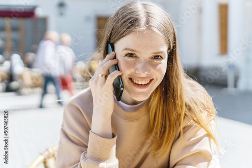 Portrait of a freelance woman using a phone talking.