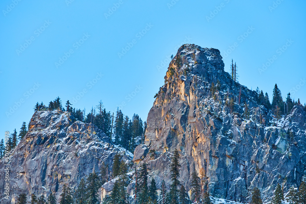 Golden light grazing cliffs with snowy peaks at Yosemite