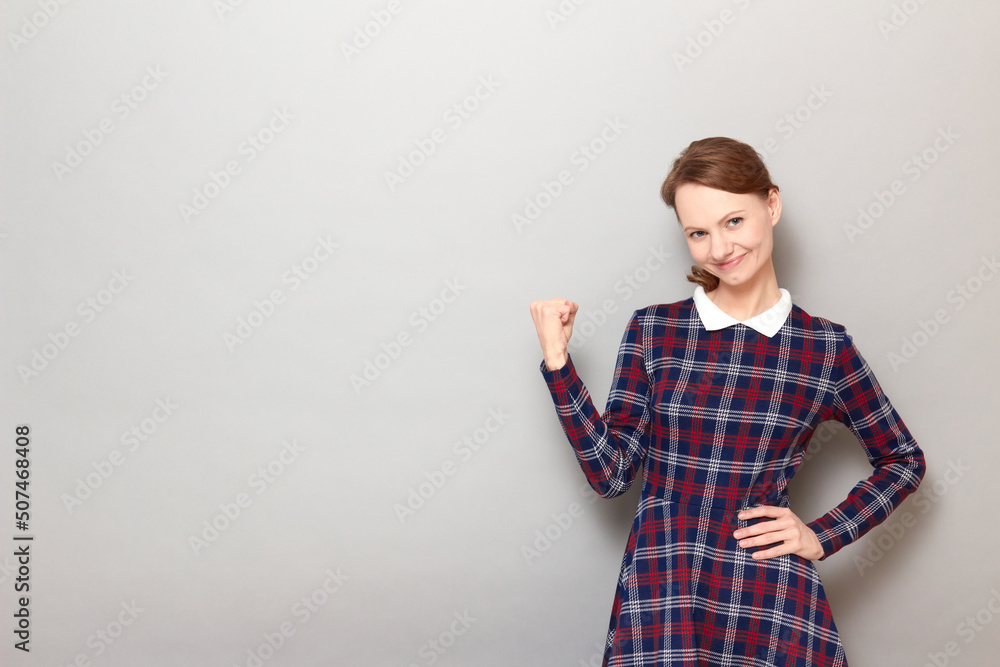 Portrait of happy young woman raising fist up and smiling cheerfully Portrait of happy young woman raising fist up and smiling cheerfully