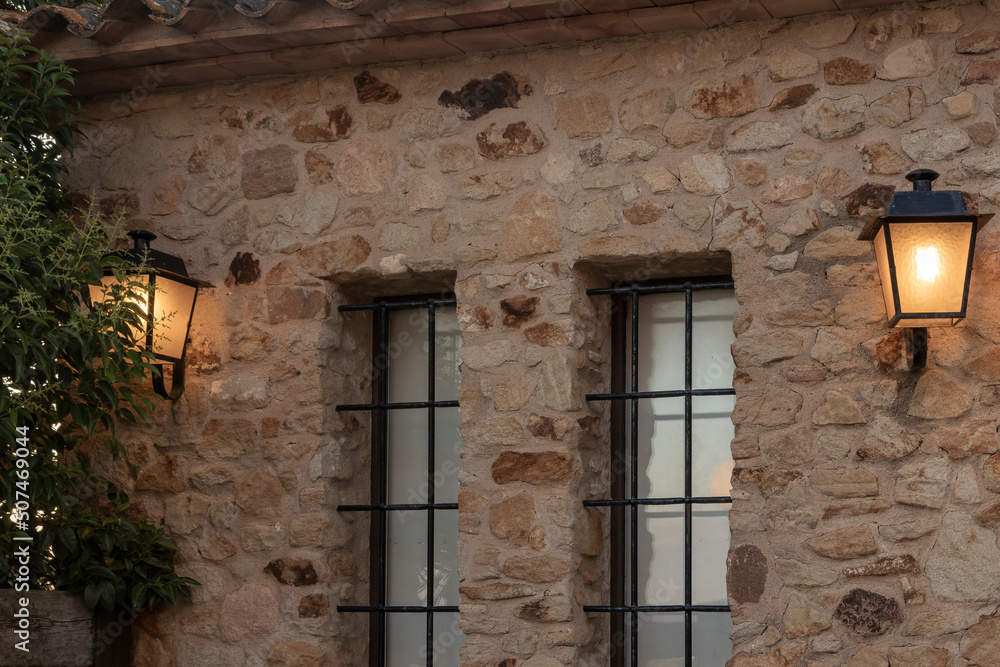 lantern on a stone wall in the medieval village of pals on the costa brava lantern on a stone wall in the medieval village of pals on the costa brava