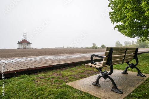 A wooden boardwalk and an empty beach on a foggy afternoon in Toronto's Beaches neighbourhood shot in May.