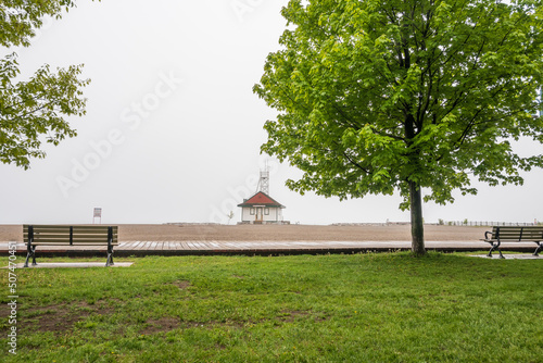 Photography A wooden boardwalk and an empty beach on a foggy afternoon in Toronto's Beaches neighbourhood shot in May