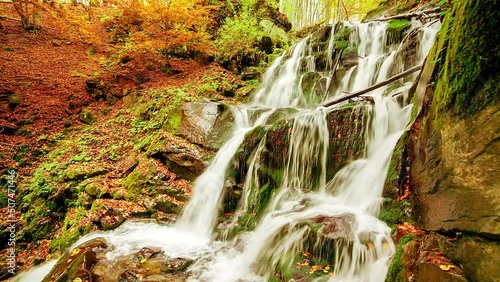 Ukpaine. Waterfall among the mossy rocks. Beautiful landscape rapids on a mountains river in autumn forest in carpathian mountains at sunset. Silver stream in National park Shypit Carpat. Pilipets. photo