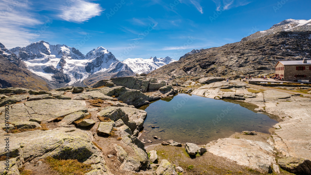 Obraz premium Fuorcla Surlej is a mountain pass in the Swiss Alp (connecting the Upper Engadine Valley with Roseg Valley) with stunning views on the Bernina Massif. There is also a small lake and a mountain hut.