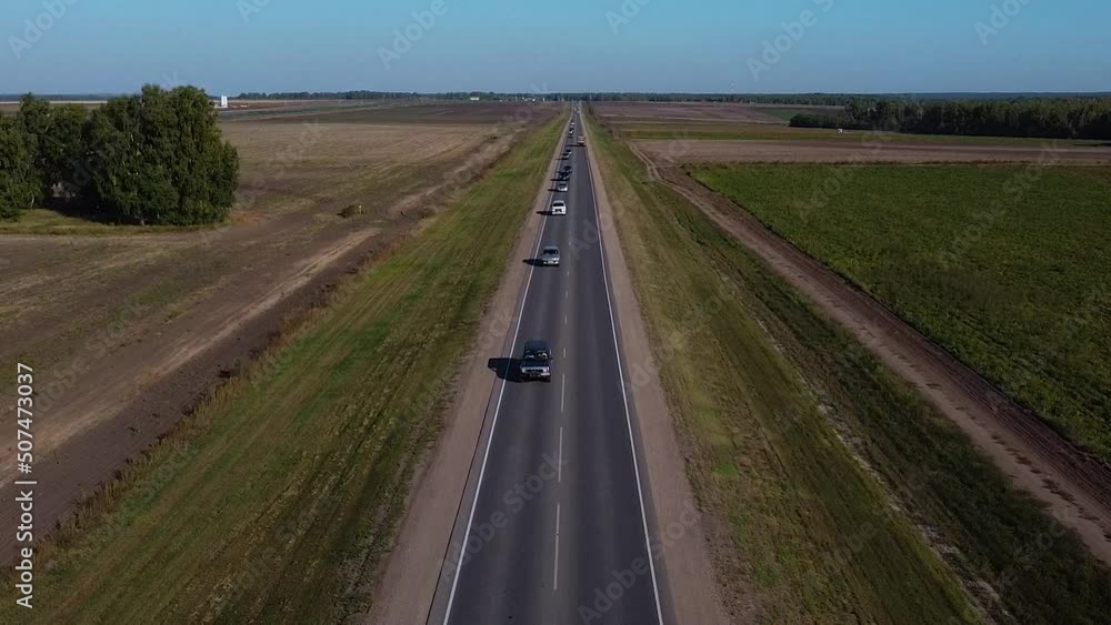 Intercity traffic among the fields of Siberia, drone view of traffic between cities Intercity traffic among the fields of Siberia, drone view of traffic between cities